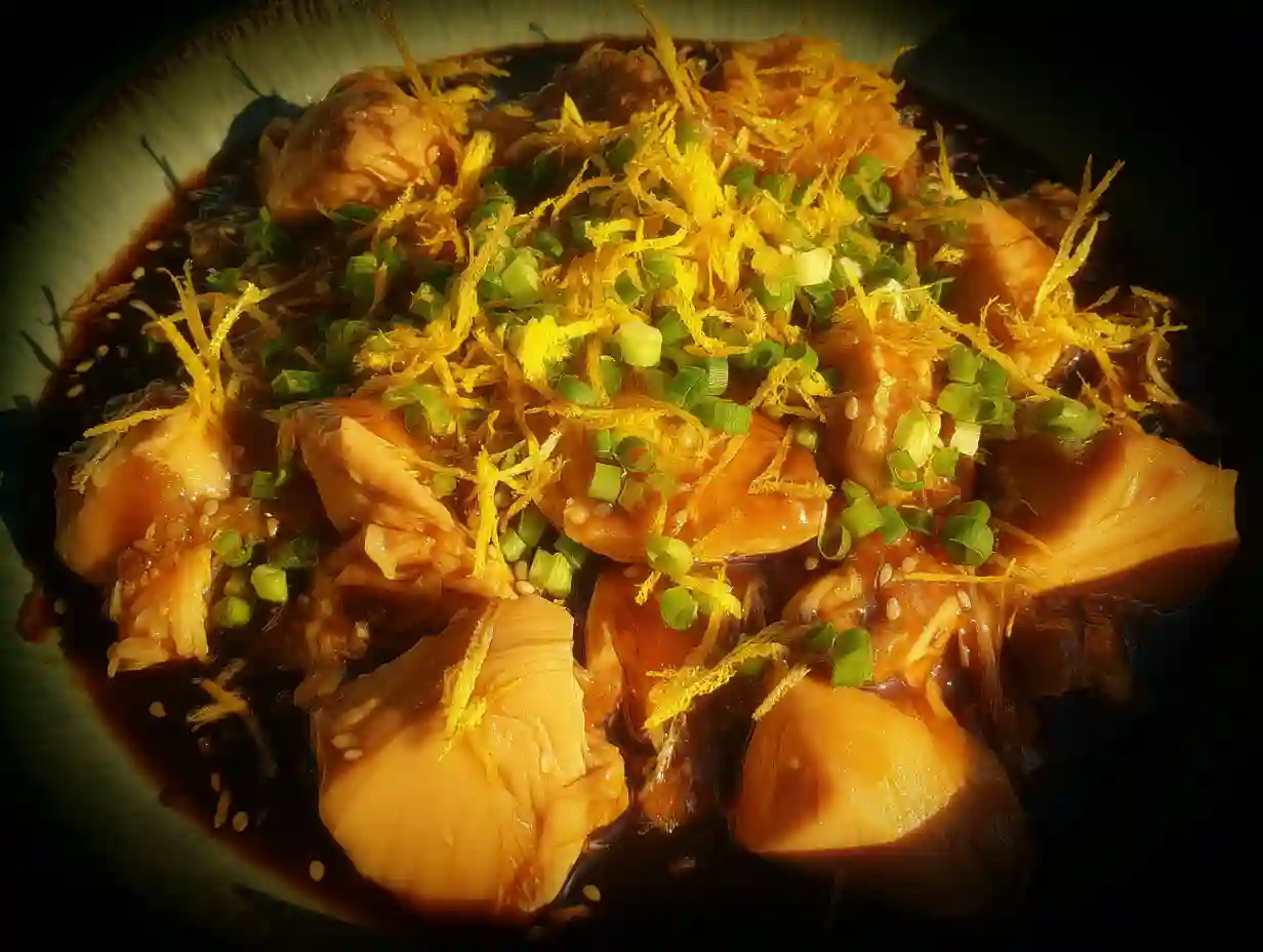 Slow Cooker Orange Chicken 2 Slow cooker orange chicken served in a bowl, topped with orange sauce and fresh herbs