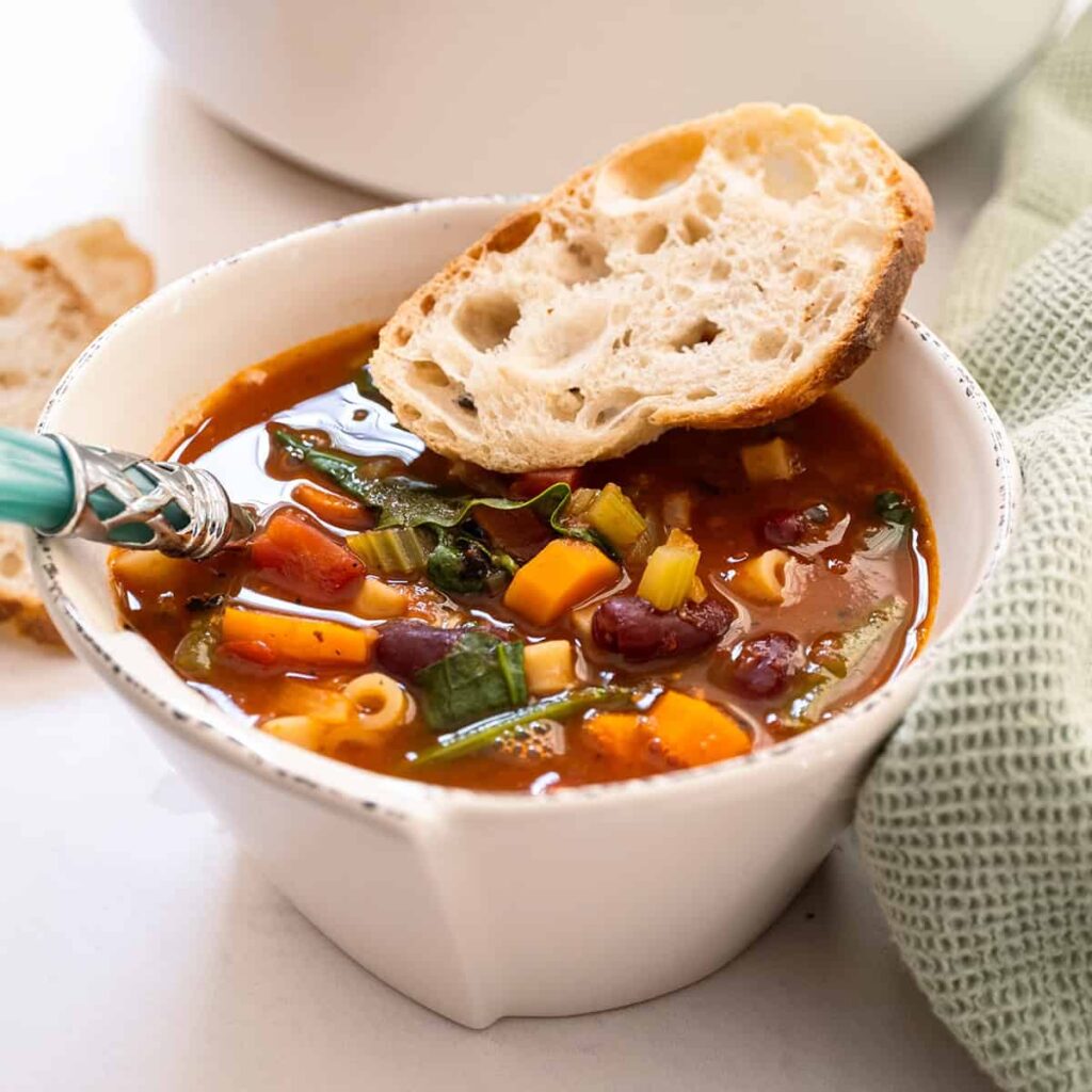 Classic Italian minestrone soup with vegetables, beans, and pasta served with crusty bread