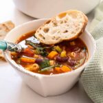 Classic Italian minestrone soup with vegetables, beans, and pasta served with crusty bread